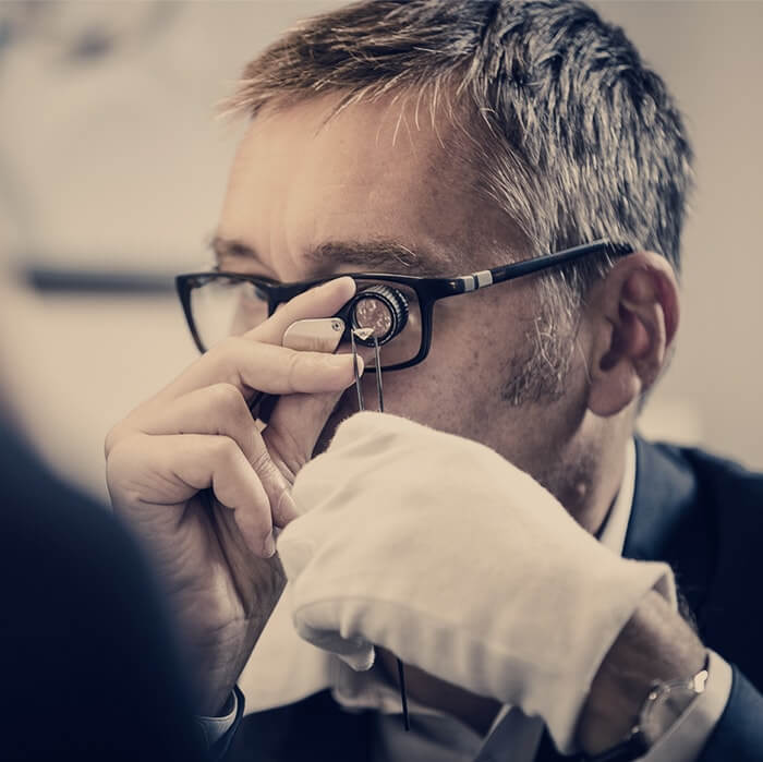 un expert diamantaire expertise un diamant à la loupe